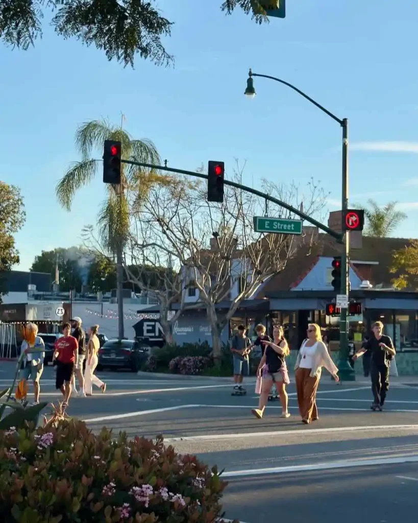 Pedestrians cross the street at a pedestrian scramble at the corner of the 101 Highway and E Street in Encinitas, California