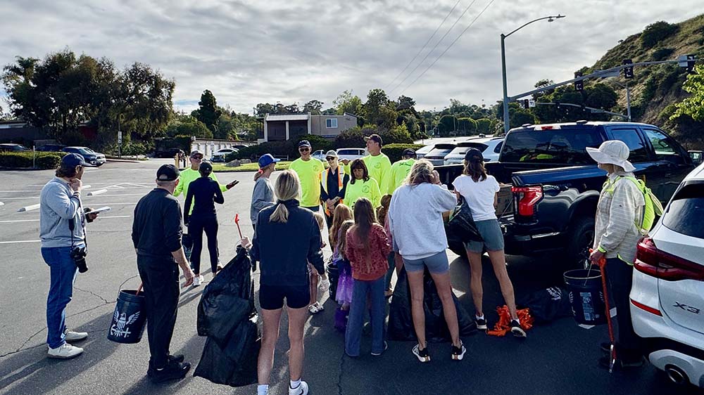 A group prepares to pick up trash along Encinitas Boulevard during a Street Stewards street cleanup in Encinitas, California